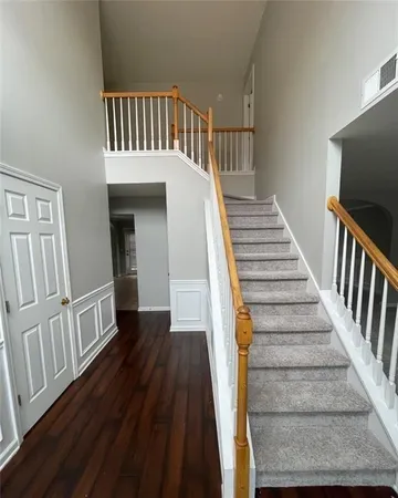 a view of staircase with wooden floor and a chandelier