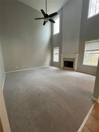 a view of an empty room with a fireplace and a window