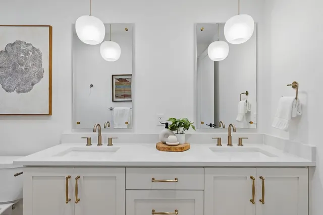 a bathroom with a granite countertop sink a toilet a mirror a vanity and shower