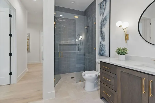 a bathroom with a granite countertop sink toilet and shower