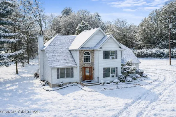 a view of a house with a yard covered in snow