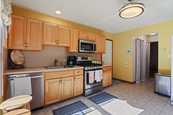 a kitchen with stainless steel appliances granite countertop a stove a sink and a microwave