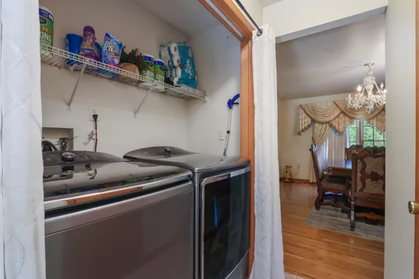 a utility room with dryer washer and a view of living area
