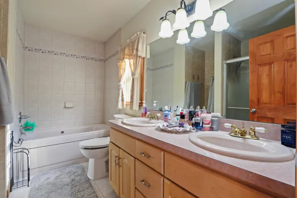 a bathroom with a double vanity sink mirror and toilet