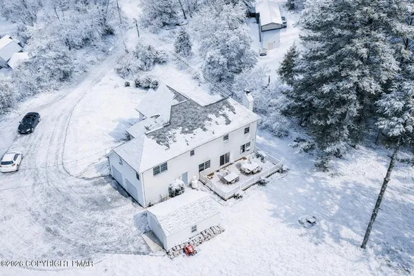 an aerial view of a wooden house with a yard