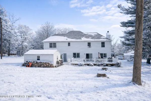 a view of a white house with a yard covered with snow in front of house