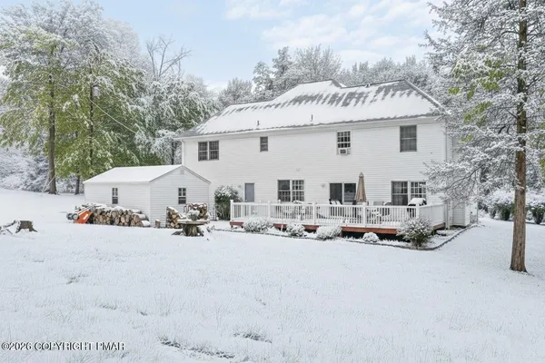 a view of a terrace with a barbeque and wooden fence