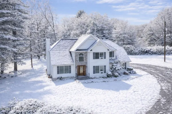 a front view of a house with a yard covered in snow