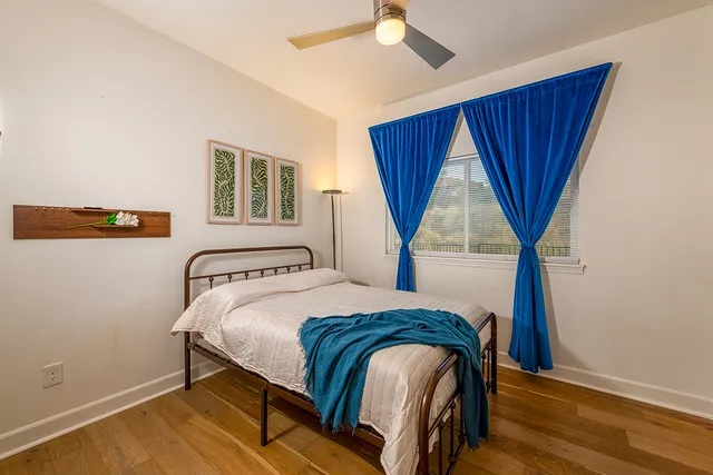 a bedroom with a bed a mirror and a window