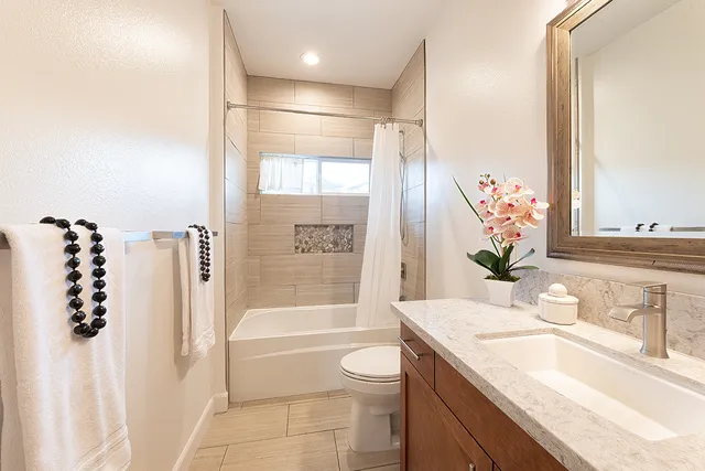 a bathroom with a granite countertop sink a toilet and shower