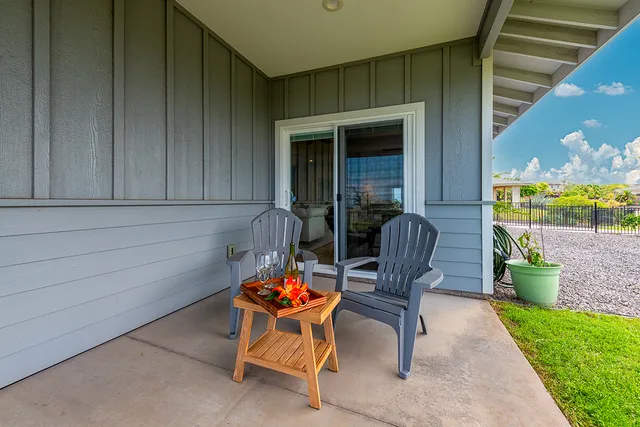 a view of a back yard with a chairs and table in the patio