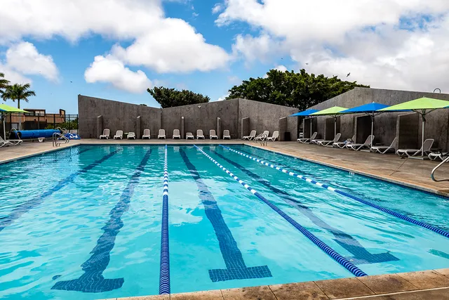 a swimming pool view with a seating space