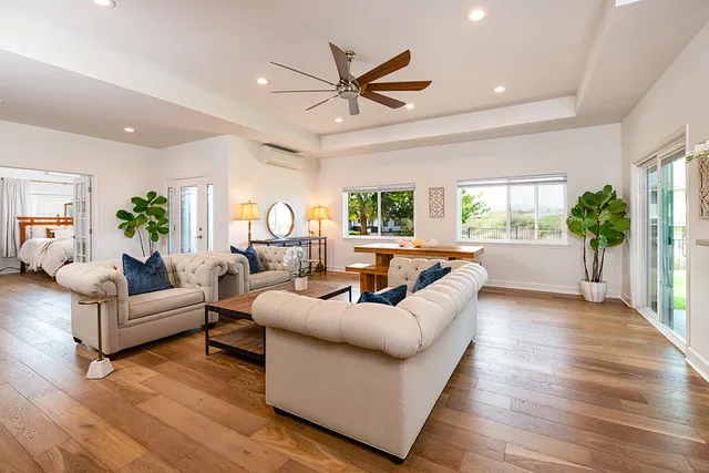a living room with furniture and a large window with wooden floor