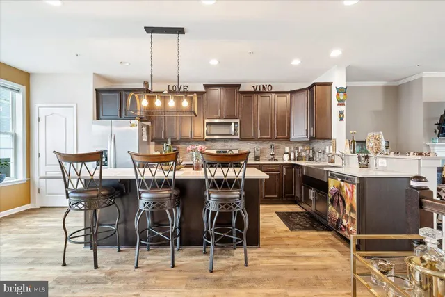a kitchen with stainless steel appliances kitchen island granite countertop a dining table and chairs