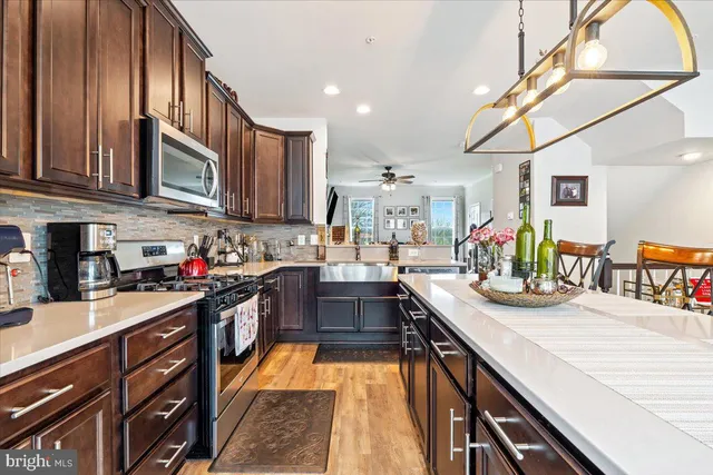 a kitchen with stainless steel appliances granite countertop sink stove top oven and cabinets