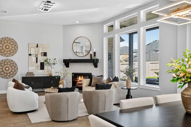 a living room with furniture a fireplace and a large window