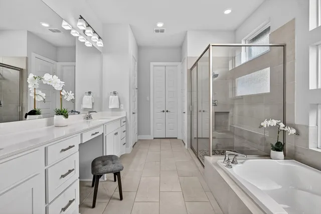 a spacious bathroom with a shower sink double vanity and mirror