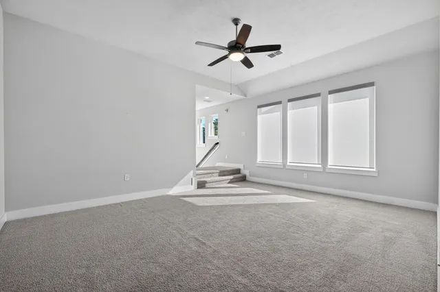 a view of empty room with ceiling fan