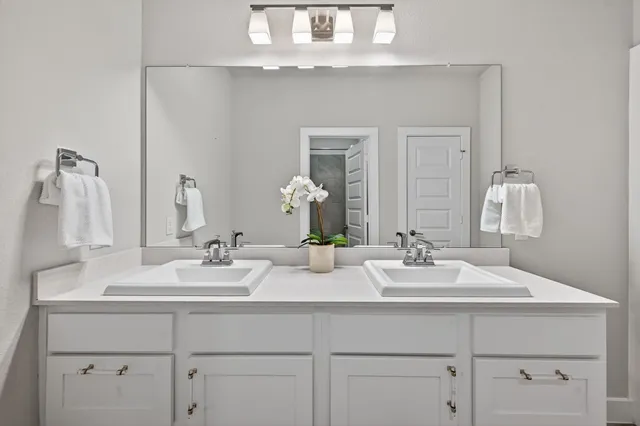 a bathroom with double sink and a mirror