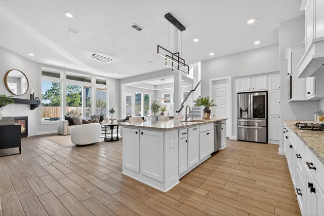 a large kitchen with stainless steel appliances kitchen island granite countertop a large counter top a sink a stove a couch and a window