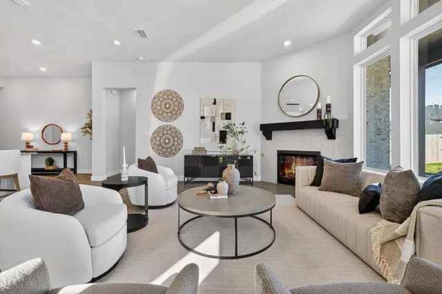 a living room with furniture a fireplace and a large window