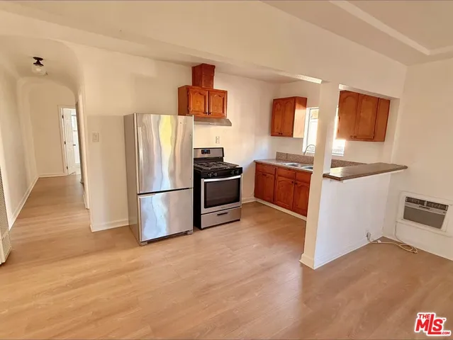 a kitchen with a refrigerator and a stove top oven
