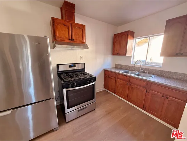 a kitchen with stainless steel appliances granite countertop a refrigerator stove and sink
