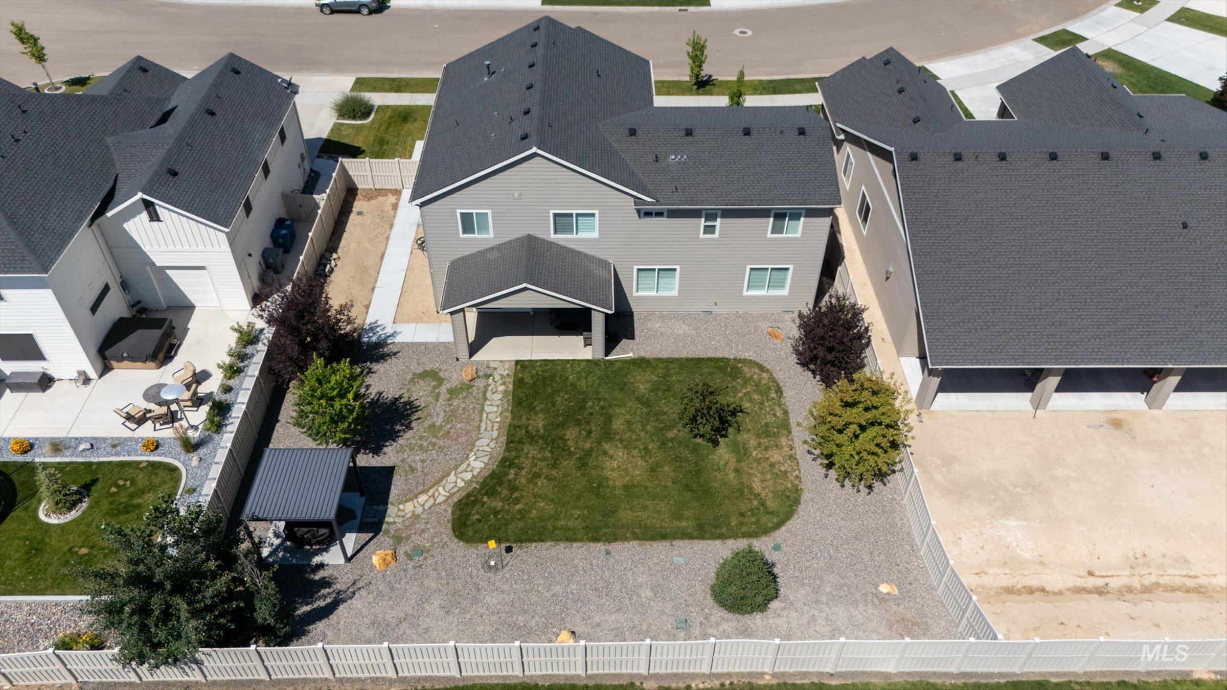2172 Savoy Court Middleton, ID 83644 - Photo 41 of 46 Expansive backyard featuring a central lawn area, decorative rock landscaping, and mature plantings