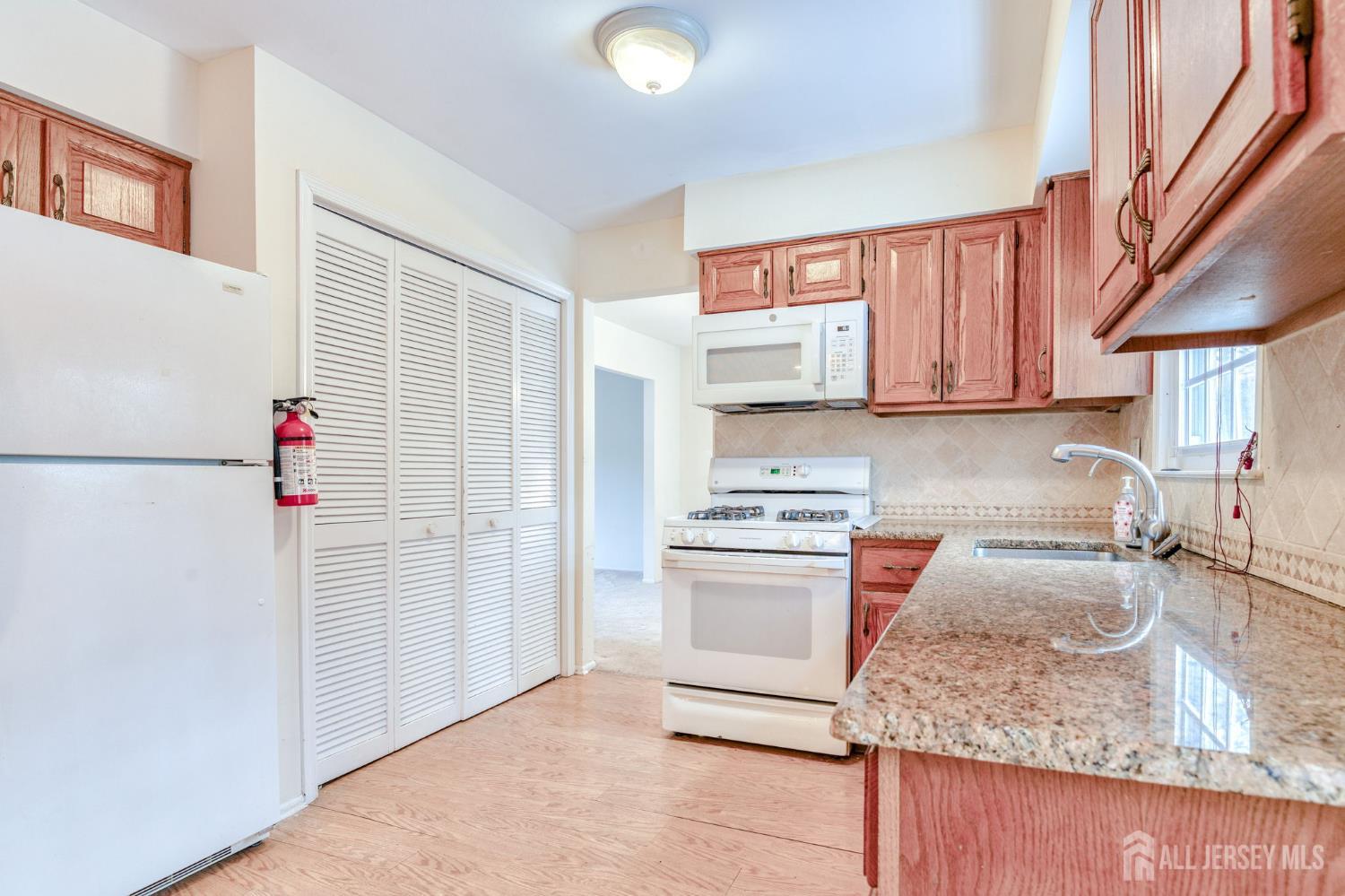 61 Ochs Avenue Milltown, NJ 08850 - Photo 8 of 29 a kitchen with stainless steel appliances granite countertop a sink and a stove