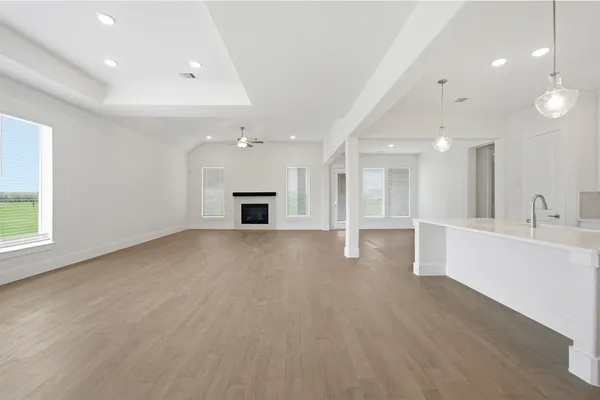 an empty room with windows and fireplace