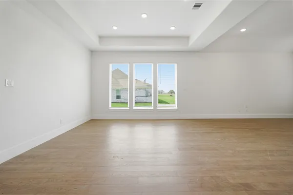 an empty room with wooden floor and fireplace