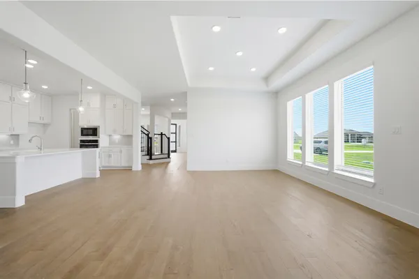 a large white kitchen with kitchen island a sink a center island stainless steel appliances and a fireplace