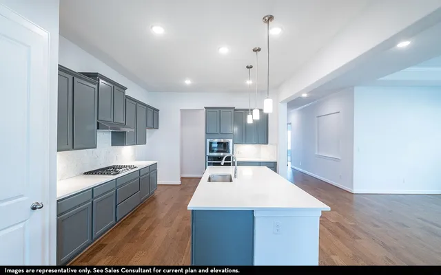 a kitchen with kitchen island white cabinets and stainless steel appliances