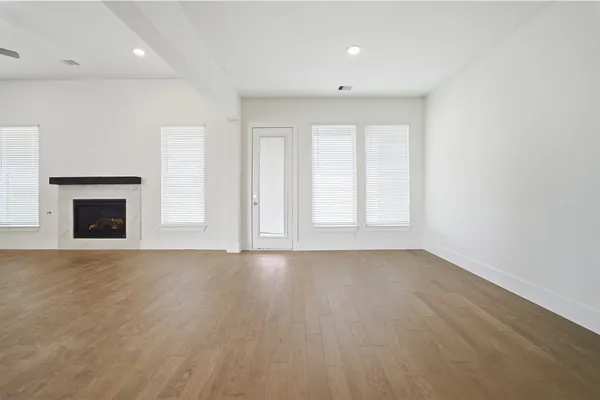 an empty room with windows and chandelier fan