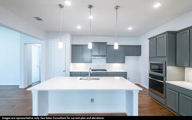 a view of a kitchen with kitchen island a sink stainless steel appliances and cabinets