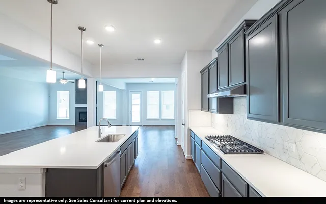a kitchen with kitchen island a sink stove and refrigerator