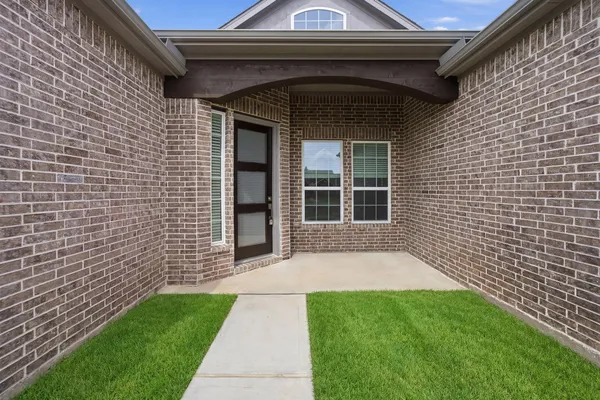 a bathroom with a granite countertop sink vanity mirror and toilet
