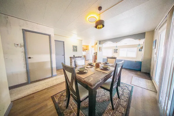 a view of a dining room and livingroom with furniture wooden floor and a rug