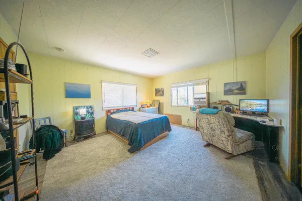 a spacious bedroom with a bed and large windows