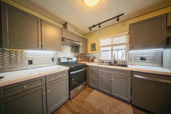 a kitchen with a sink cabinets appliances and a window