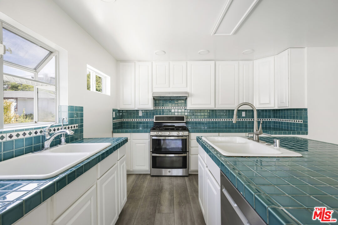 4013 Division Street Los Angeles, CA 90065 - Photo 11 of 66 a kitchen with kitchen island granite countertop a sink stove and cabinets