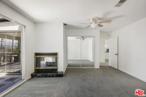 a living room with a large window and kitchen view