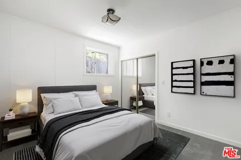 a bedroom with a bed and a flat tv screen