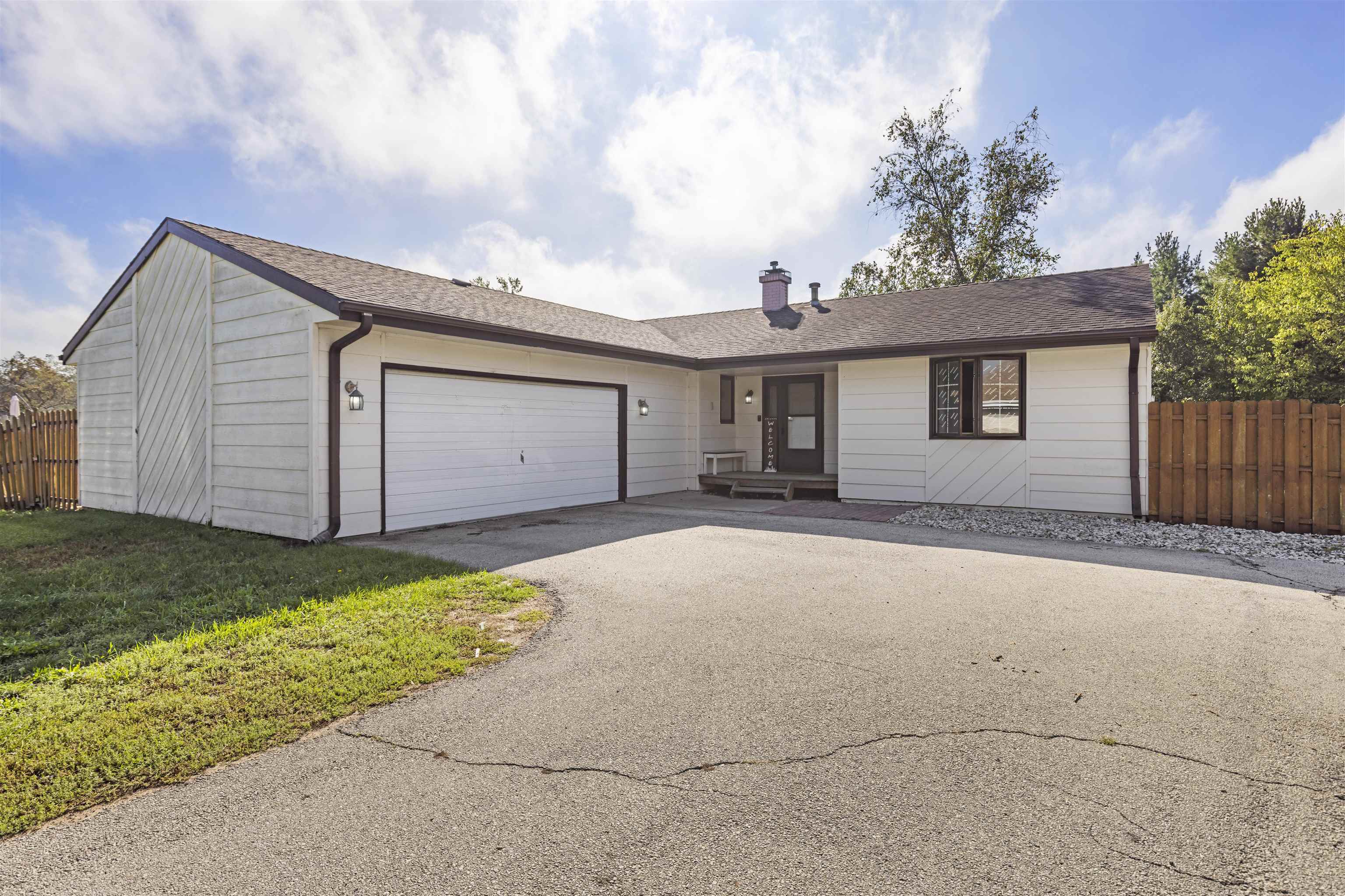 front view of a house with a yard and potted plants