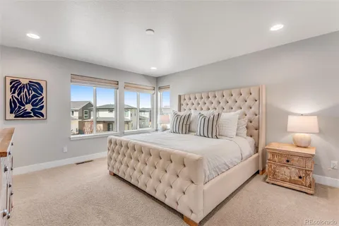 a bedroom with a large bed and a night stand