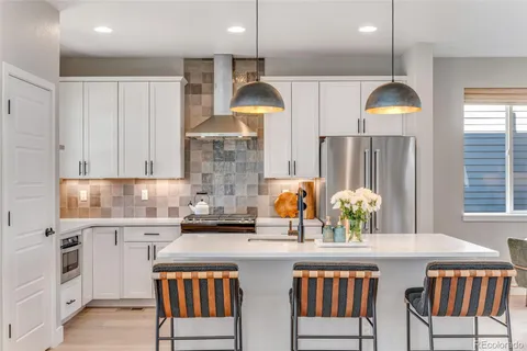 a kitchen with stainless steel appliances granite countertop a sink and a refrigerator