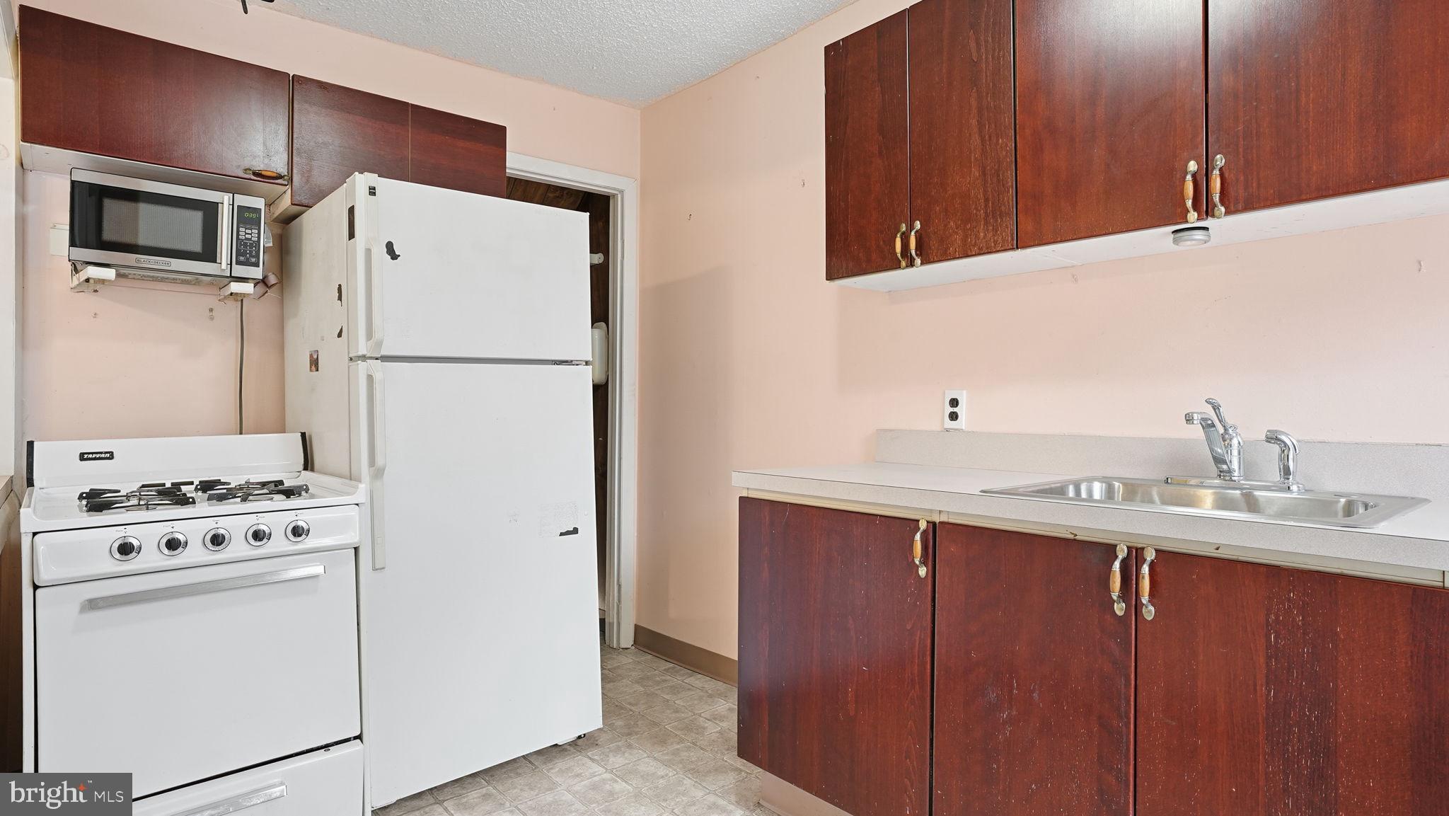 442 Wellesley Road Philadelphia, PA 19119 - Photo 18 of 36 a kitchen with a white cabinets and white appliances