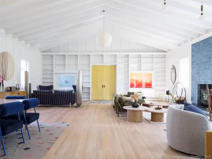 a living room with furniture kitchen view and a large window