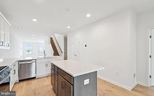 a kitchen with a sink cabinets and wooden floor