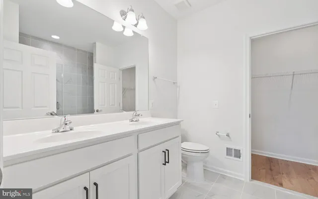 a bathroom with a double vanity sink a toilet and a mirror